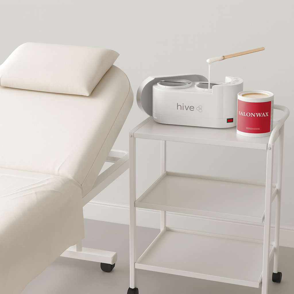 White massage table with a cart holding a 'hive' device and a container labeled 'SalonWax'.